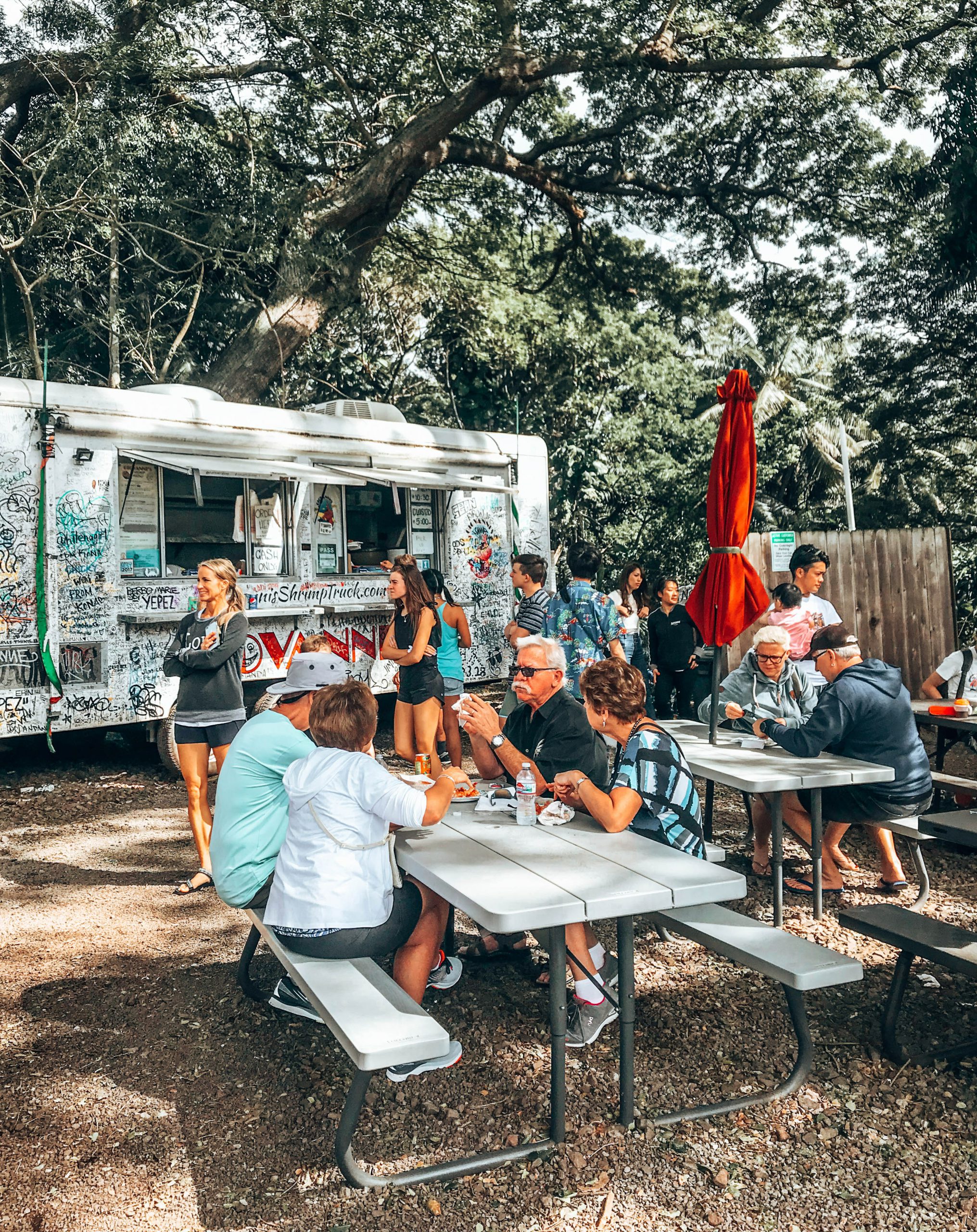 Outdoor seating area with people enjoying their meals at Giovanni's Shrimp Truck