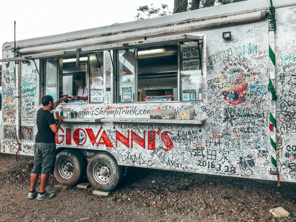 A person standing outside Giovanni's Shrimp Truck.