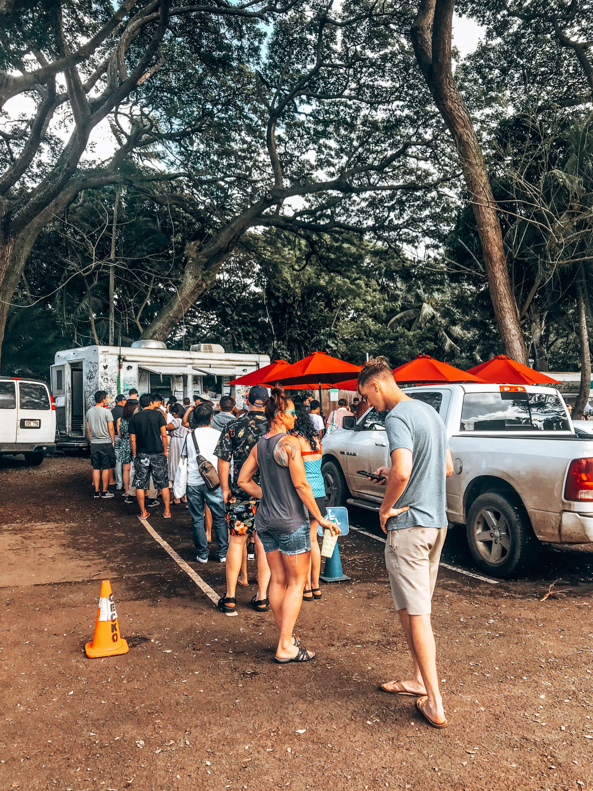 Individuals patiently waiting in line outside the shrimp truck.
